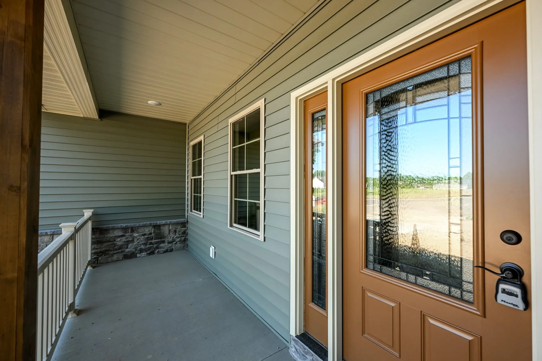 Covered front porch with a stained wood door