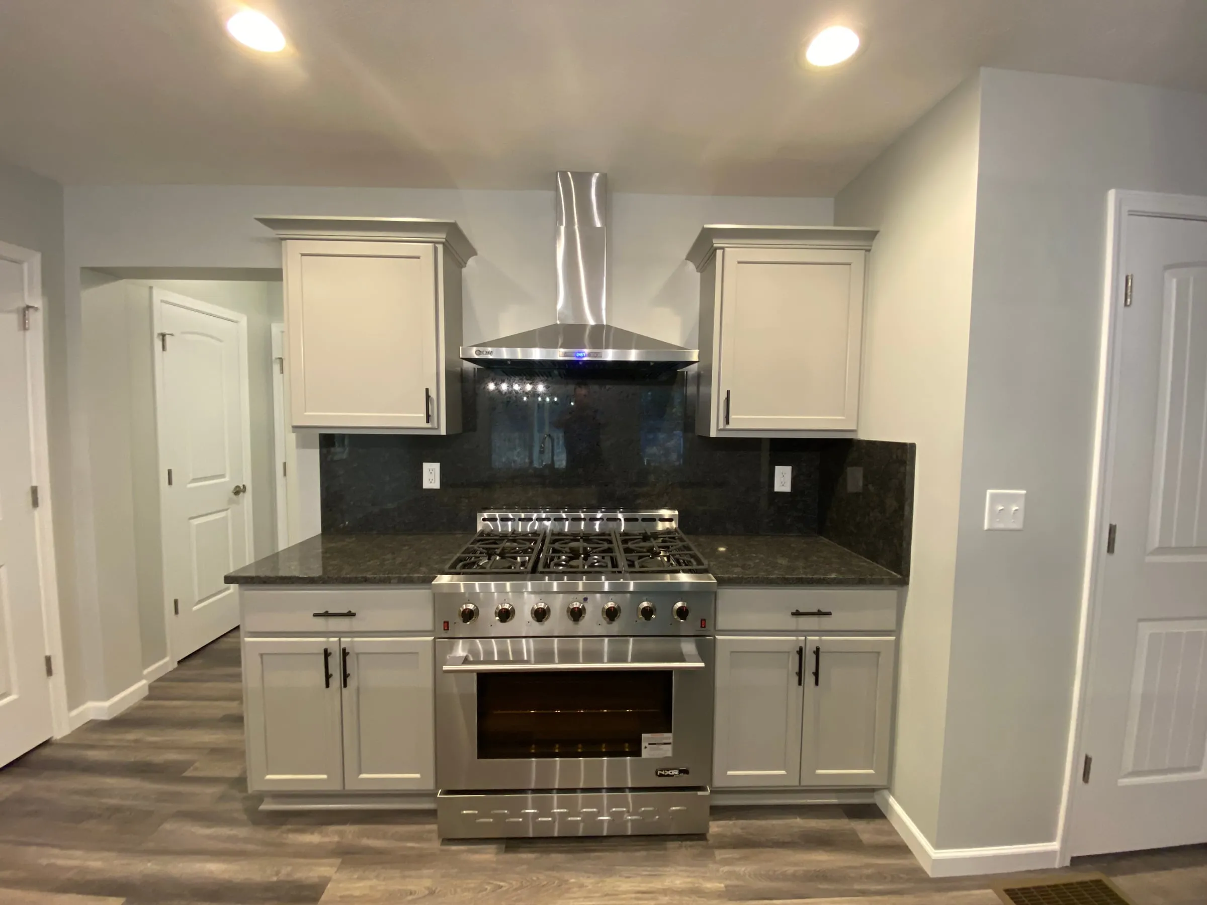 Kitchen with white cabinets, granite counters, and a professional range