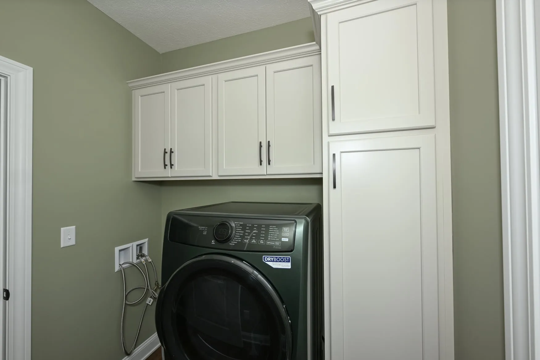 Laundry room with cabinetry above the machines