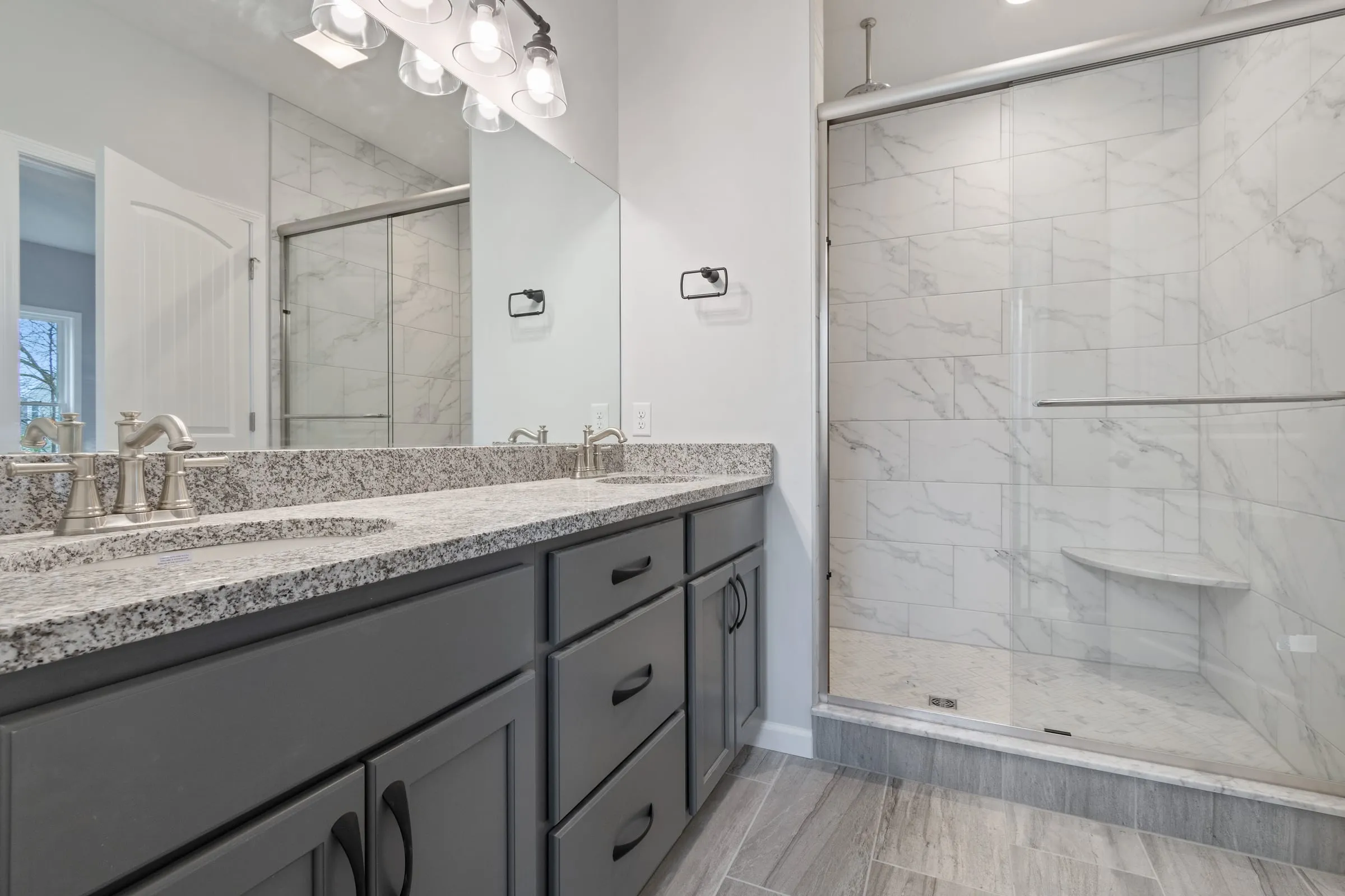 Owner's bath with double vanity and tiled shower