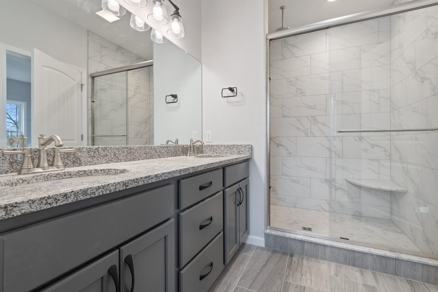 Bathroom with a double vanity and tiled walk-in shower