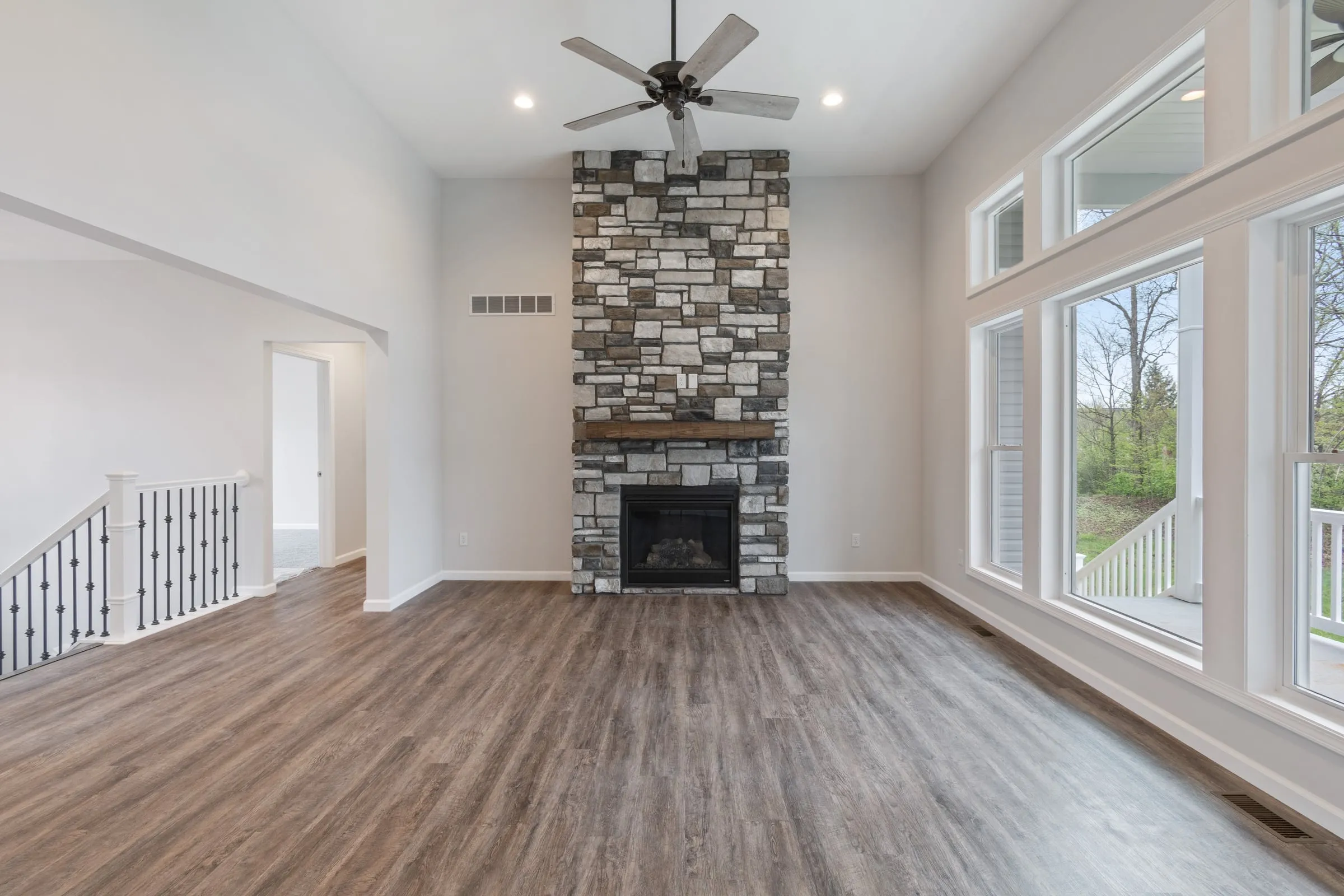 Stone fireplace and staircase in a Hahn home great room