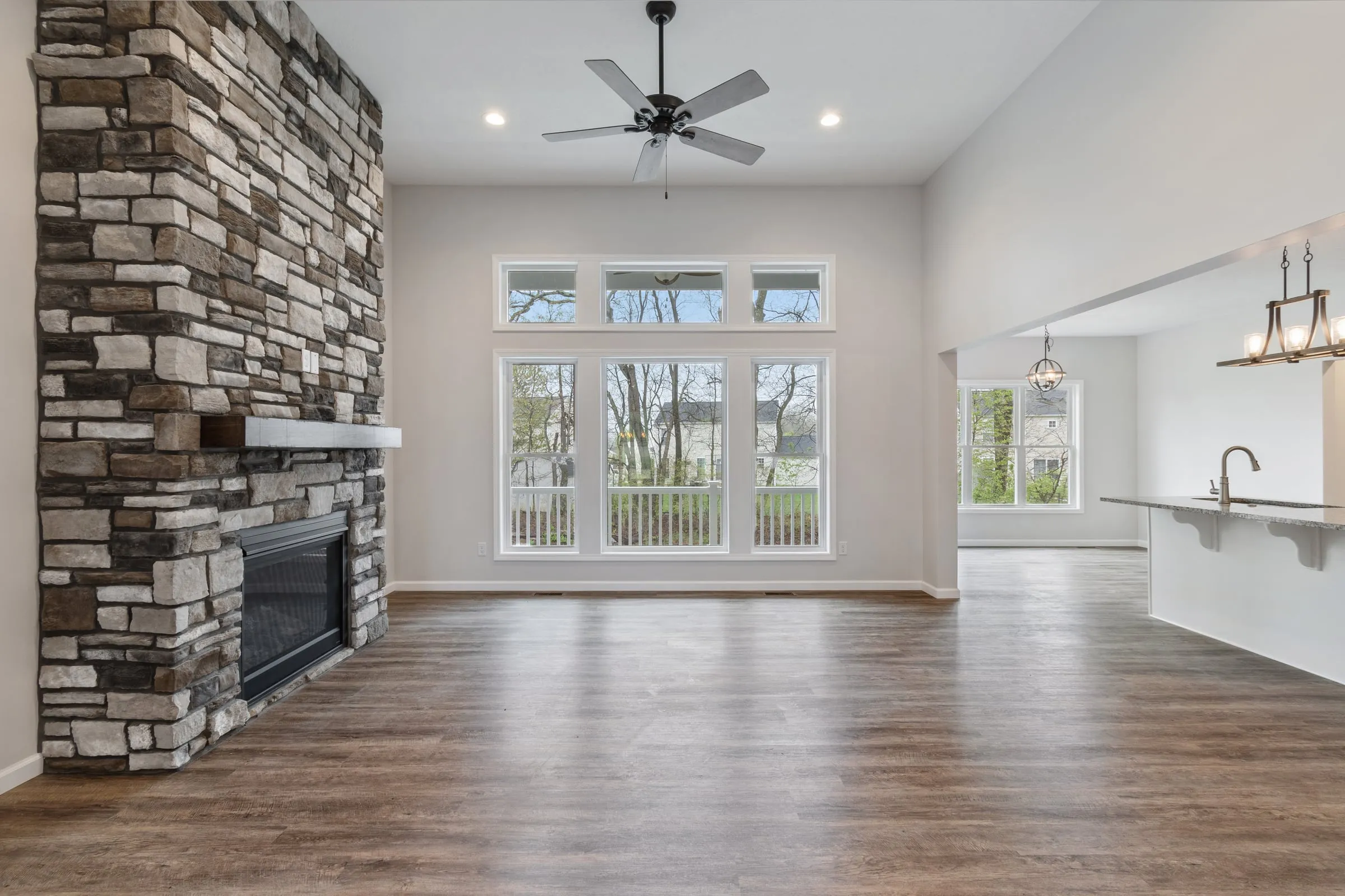 Great room with stone fireplace and tall windows